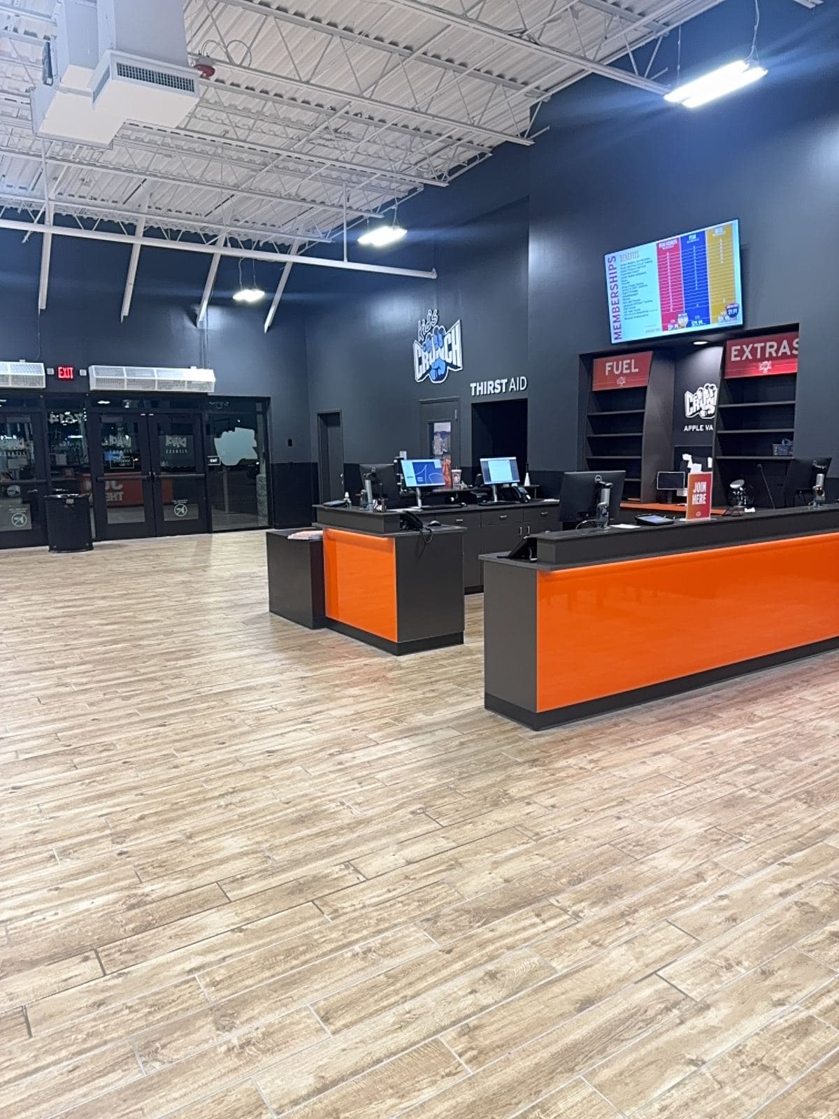 Crunch Fitness front lobby with branded welcome desk, opening ready