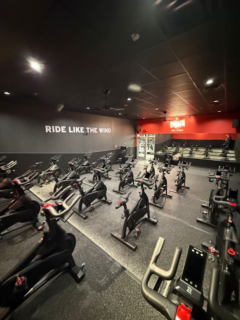 Ride studio with rows of spin bikes under a Ride Like the Wind wall