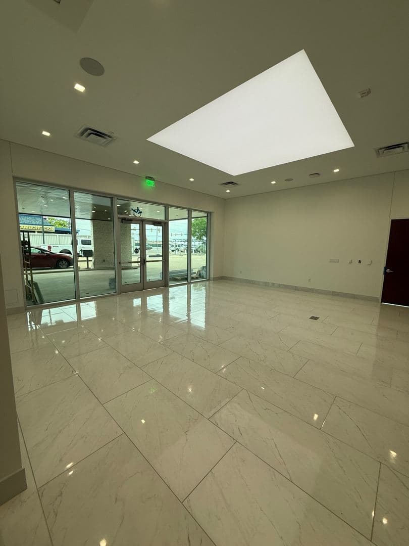Gilchrist Automotive dealership lobby, marble floor gleaming after final clean